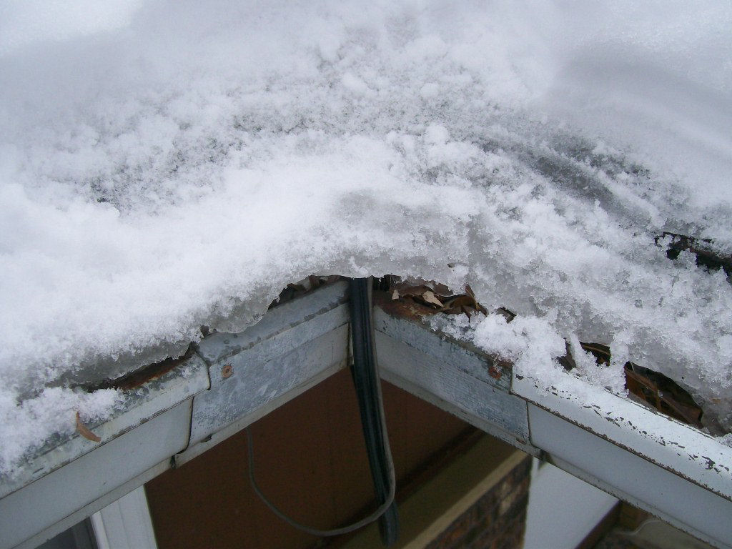 Frozen gutter with snow and ice buildup